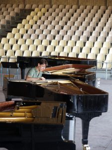 Quatre pianos de concert accordés ensemble avant une représentation