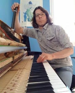 Accordeur de piano réglant un piano droit à Nantes