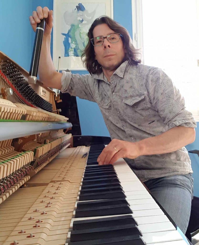 Accordeur de piano réglant un piano droit à Nantes